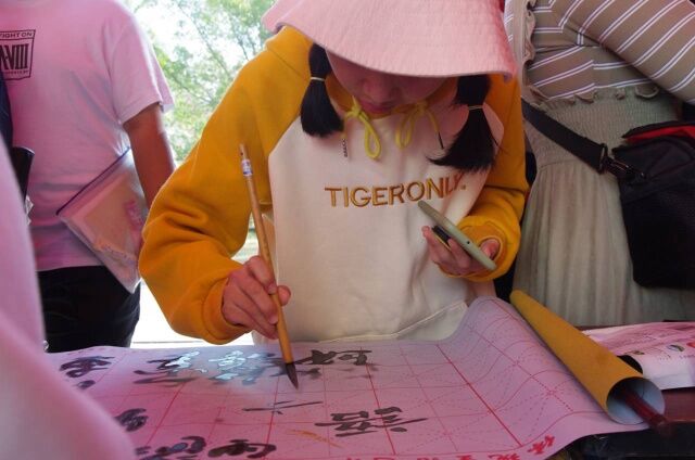 01体验同学正参与“走过文字的前世今生”活动,用笔尖书写自身经历,用墨汁描摹未来憧憬